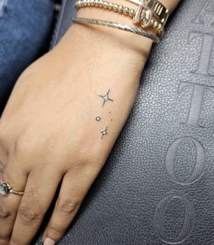Fine line stars hand tattoo
